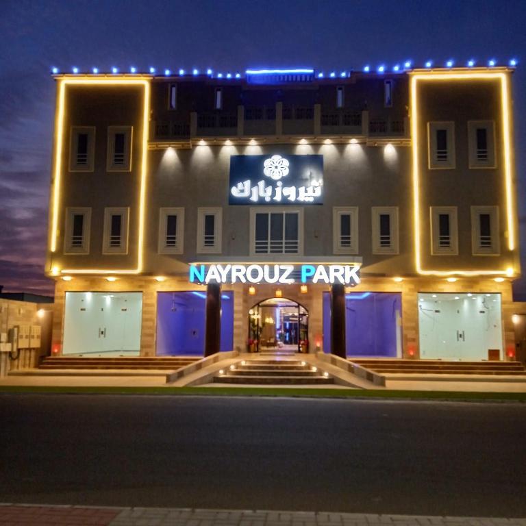 a night view of a hotel with arazykos park sign at نيروز بارك in Najran