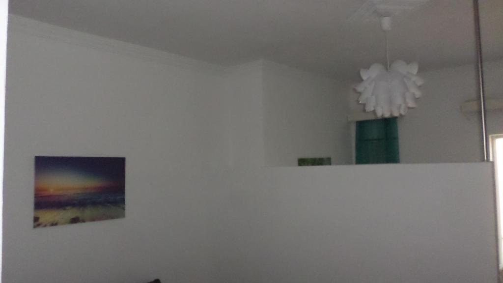 a white room with a picture and a chandelier at Summer Holidays Studio in Chania