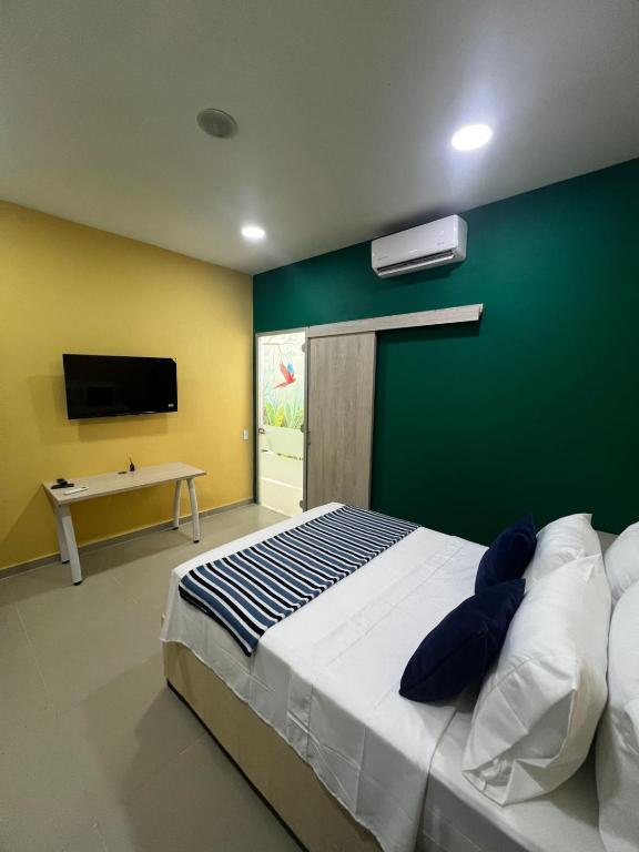 a bedroom with a large bed with a green wall at Muramar 43 Hotel Cartagena in Cartagena de Indias