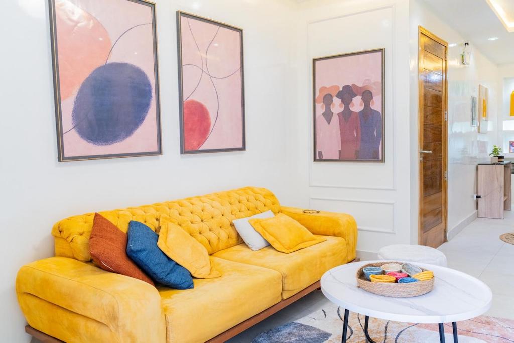 un soggiorno con un divano giallo e un tavolo di Jaara Home - High standing and luxurious 2-bedroom apartment - Maristes a Dakar