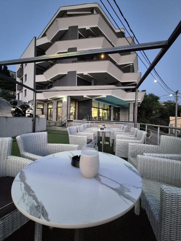 a white table and chairs in front of a building at Sky Aslan Mostar in Mostar