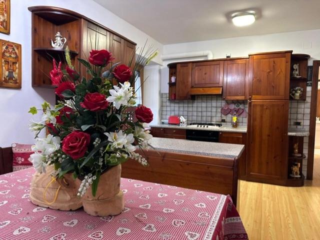 a kitchen with a vase of roses on a table at Casa Capon in Santo Stefano di Cadore
