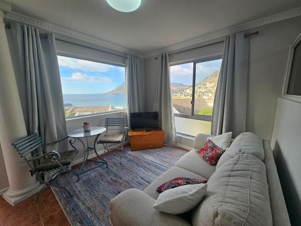 a living room with a couch and a large window at Villa Zoe in Glencairn