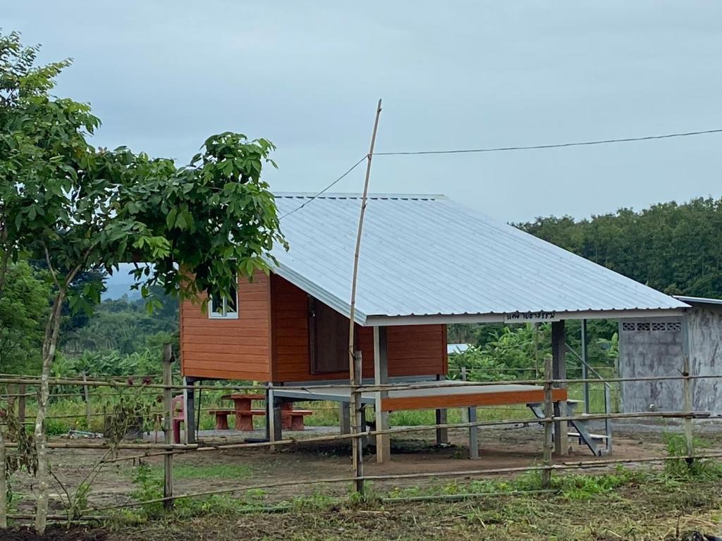 บ่อแก้วโฮมสเตย์的一座带金属屋顶的小木房子