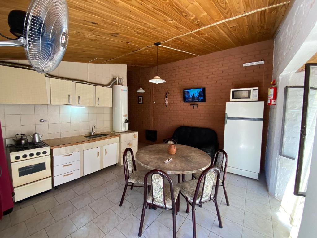 a kitchen with a table and chairs and a refrigerator at Complejo el trébol in Potrerillos