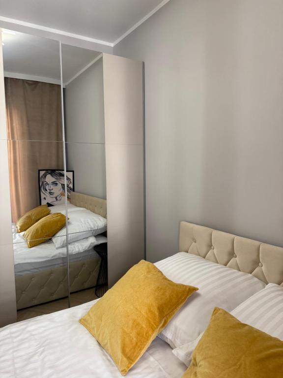 a bedroom with two beds and a mirror at Apartament Comfort Wrocław in Wrocław