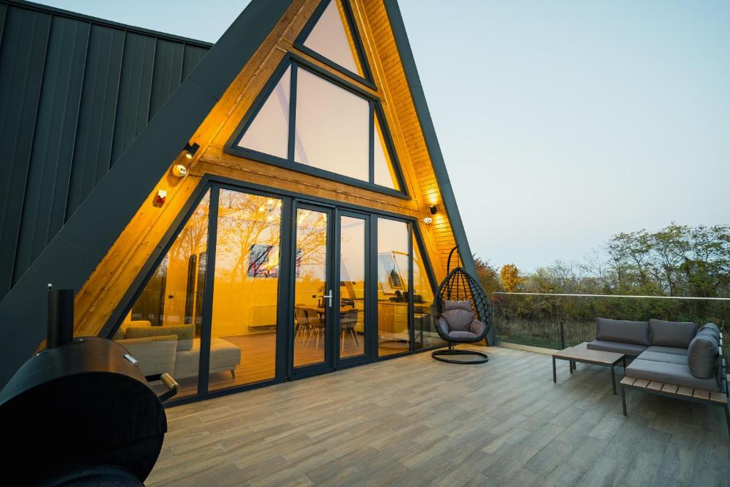 a house with a large window on a deck at Domaine A Chalet in Malu Roşu