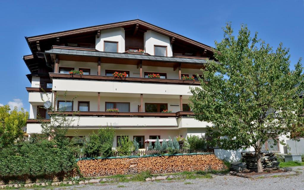 budynek z balkonami i drzewem przed nim w obiekcie Appartementhaus Kaltenbach-Stumm by PiaundDirk w mieście Stumm