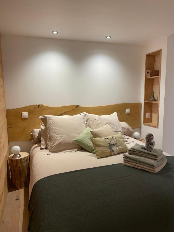 Un dormitorio con una cama grande con muchas almohadas en La marmotte qui papote, en Le Grand-Bornand