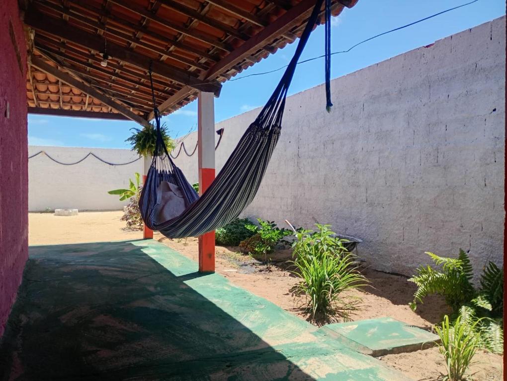 un hamac suspendu à une pergola dans l'établissement Hostel Mamitchesca - Redes e Barracas, à Aracati