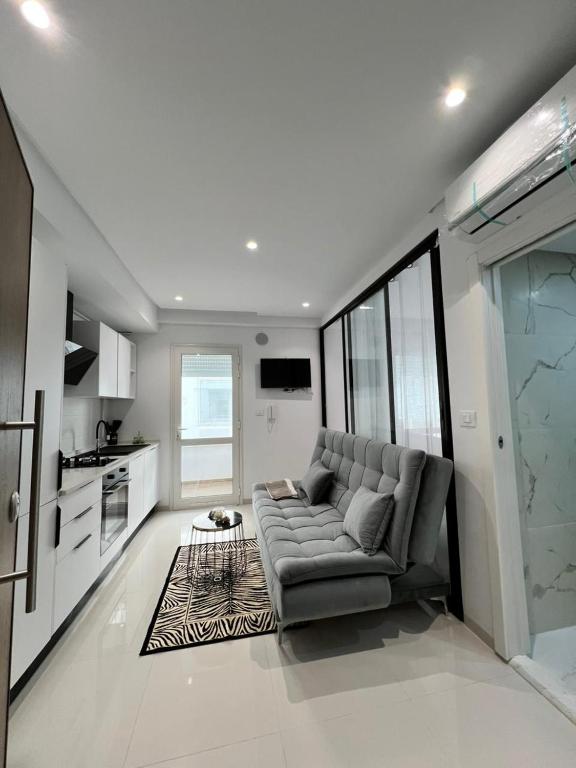 a living room with a couch and a kitchen at Appartement à louer in Sousse