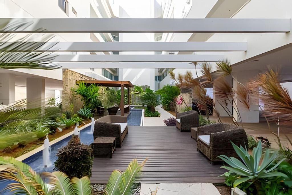 een binnenplaats met stoelen en planten in een gebouw bij Lindo Apto, Prédio beira mar c/ Piscina e Hidro in Cabo Frio