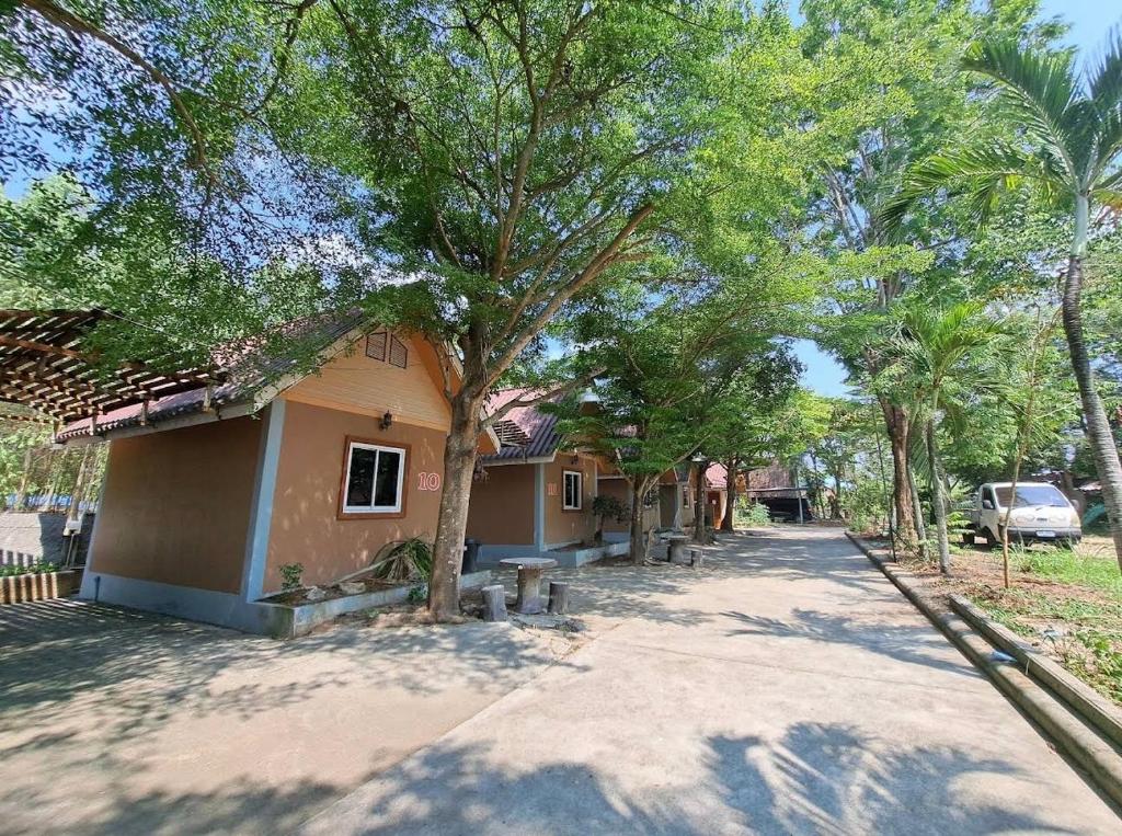 een huis met veel bomen ervoor bij คันทรี รีสอร์ท 