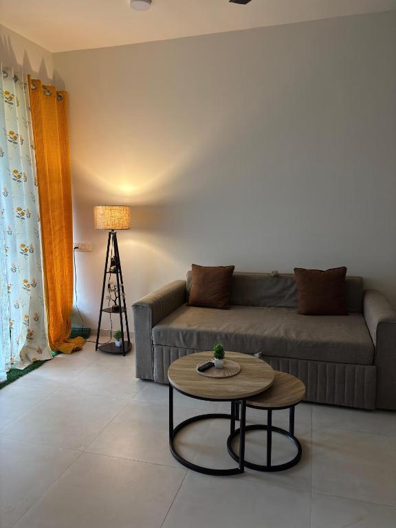 a living room with a couch and a table at Staymisty igatpuri in Igatpuri