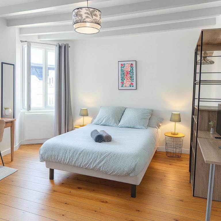a bedroom with a bed with two hats on it at Studio moderne, cosy & lumineux Chez Suzanne in Angers