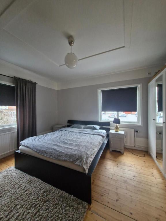 a bedroom with a bed and two windows at Rymlig lägenhet I hjärtat av Lindesberg 95kvm in Lindesberg