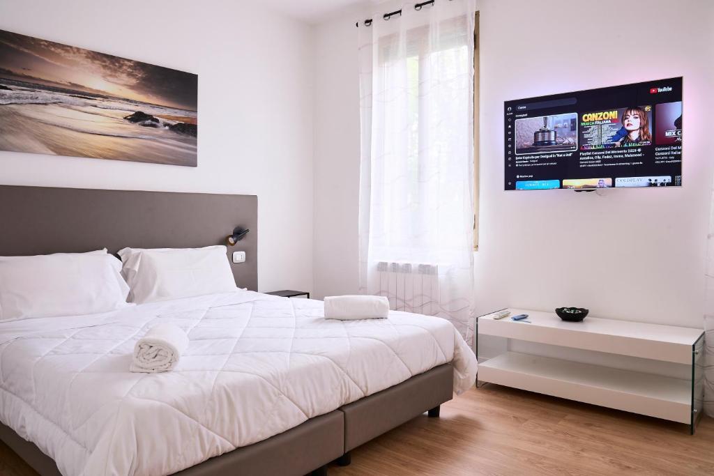 a bedroom with a large white bed and a large window at Dimora Castelli Free Parking in Marghera