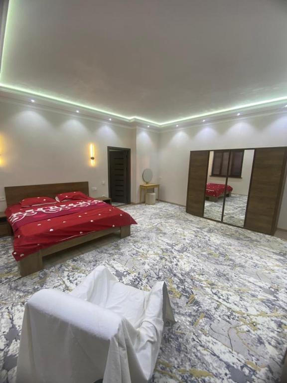 a bedroom with a red bed and a large mirror at Best Apartments in Khujand