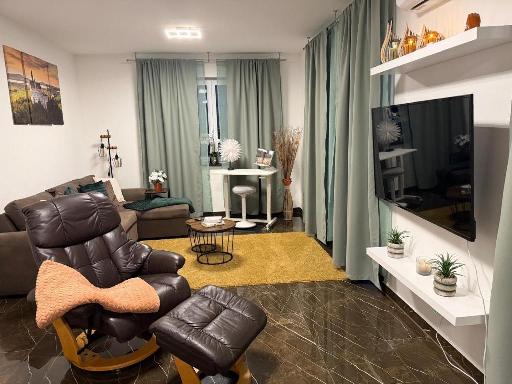 sala de estar con sillón de cuero y sofá en Ferienwohnung-Weinstadt, en Weinstadt