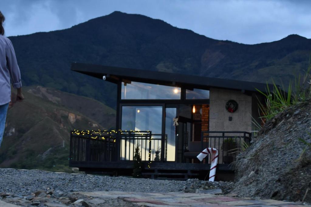 una persona in piedi davanti a una casa su una montagna di Tampu Wasi a Vilcabamba