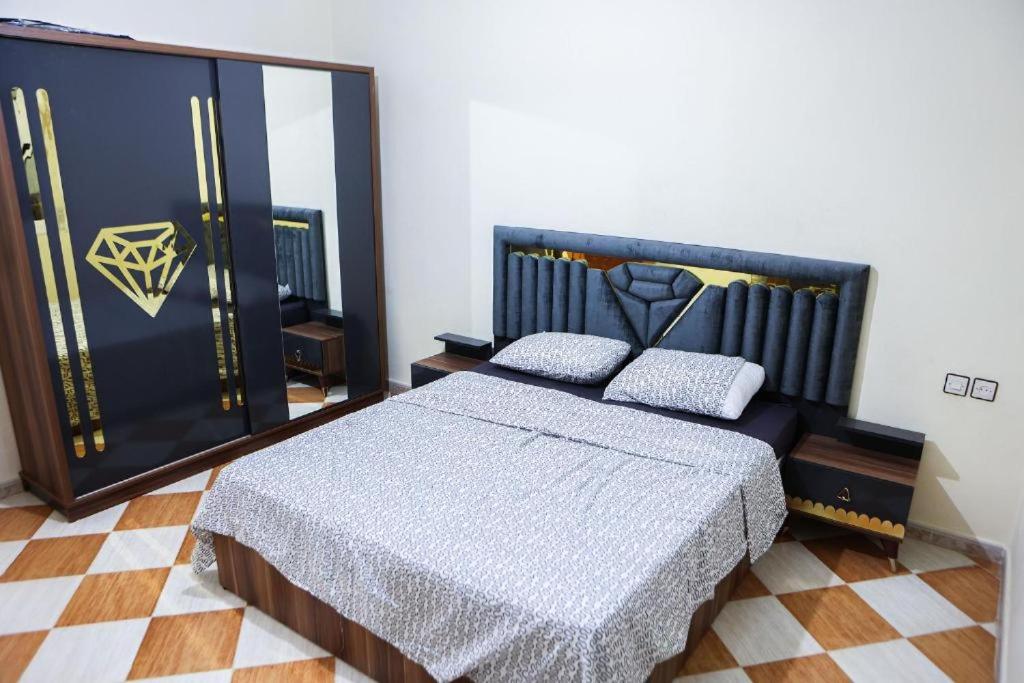 Un dormitorio con una cama grande y un espejo. en najmatriff, en Driouch