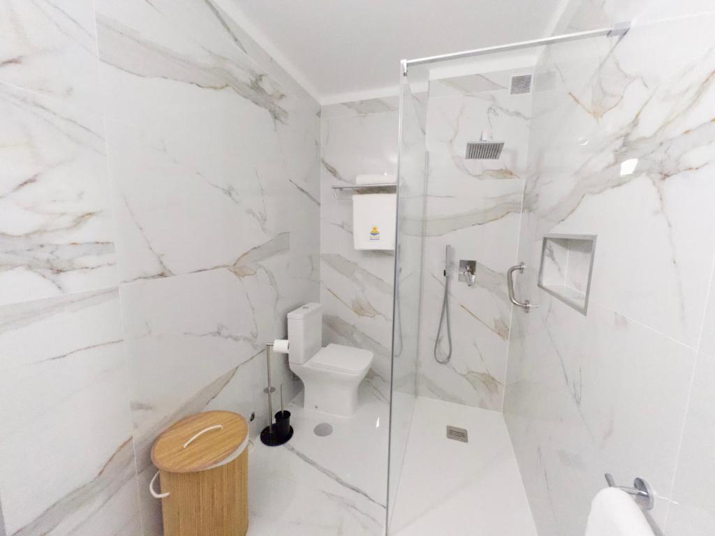 a white bathroom with a shower and a toilet at Dunas Sea and Sun Alvor in Alvor