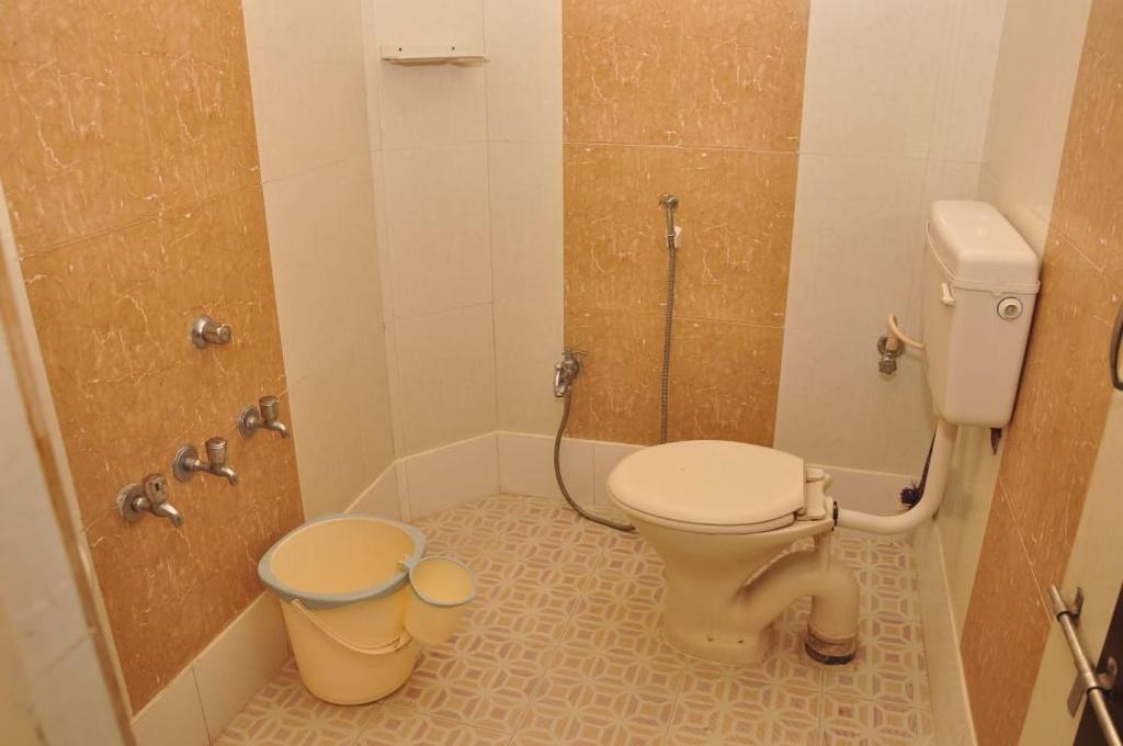 a bathroom with a toilet and a shower at DPD Beach Hotel in Puducherry