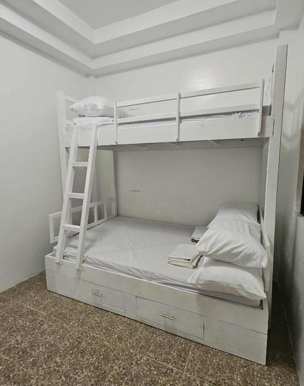 a white bunk bed with a ladder in a room at Duck and Drift Hostel - A sleeper Hostel in Puerto Princesa City