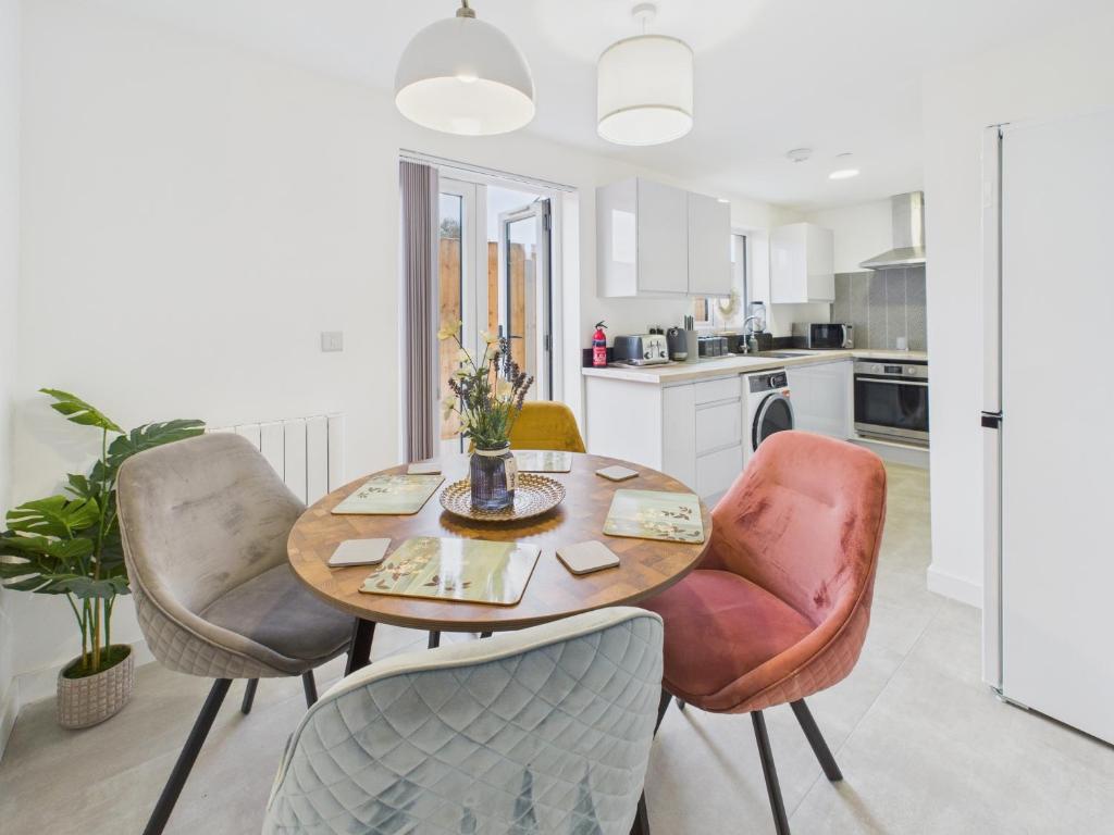 a kitchen with a wooden table and chairs at Green Hat Stays Newport City in Newport