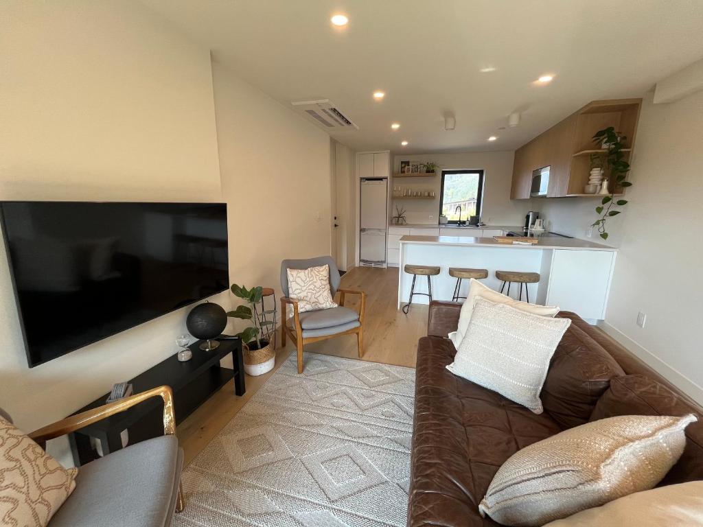een woonkamer met een bank en een grote televisie bij 2BR, Views, Spacious, Luxury, New Home in Whistler