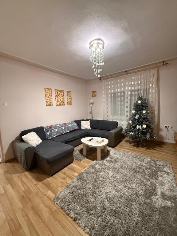 ein Wohnzimmer mit einer Couch und einem Weihnachtsbaum in der Unterkunft Kitti Kuckója in Debrecen