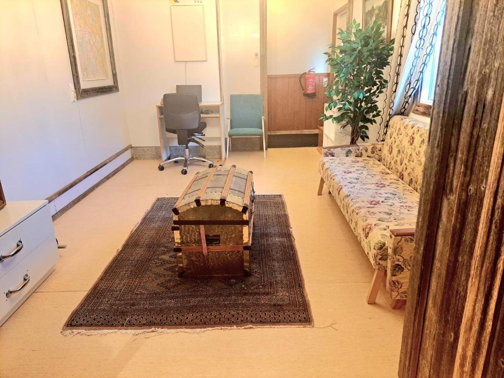 Ein Zimmer mit einer Couch und einem Tisch auf einem Teppich in der Unterkunft Hopeaniitty in Huittinen