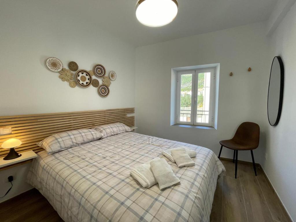 a bedroom with a bed and a desk and a window at Las Calas departamento ideal! in Sotillo de la Adrada
