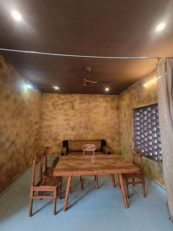 una sala da pranzo con tavolo e sedie in legno di Sp Queens Garden a Madurai