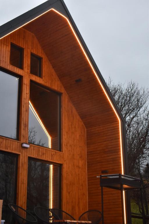 ein Haus mit einem großen Fenster an der Seite in der Unterkunft Kolibe Doftana in Trăisteni