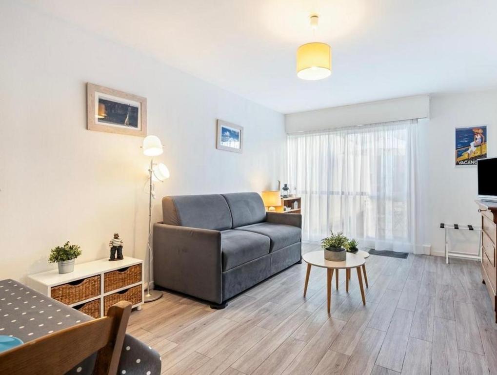 een woonkamer met een bank en een tafel bij La petite boucane in Fécamp