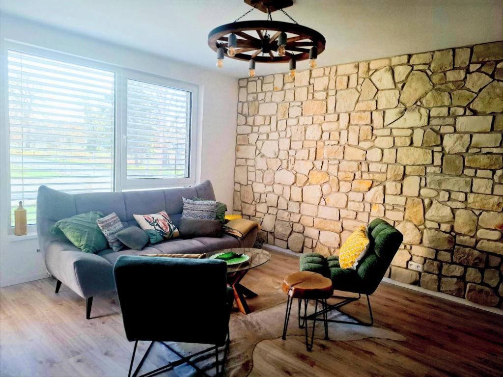 ein Wohnzimmer mit einer Couch und einer Steinwand in der Unterkunft Sugar Apartment 41A in Trnava