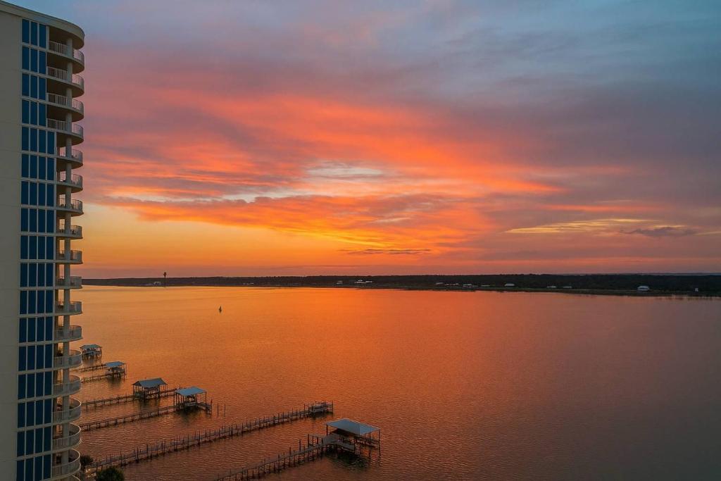 a sunset over a large body of water at Bel Sole 1102 Spacious water view beach access in Gulf Shores