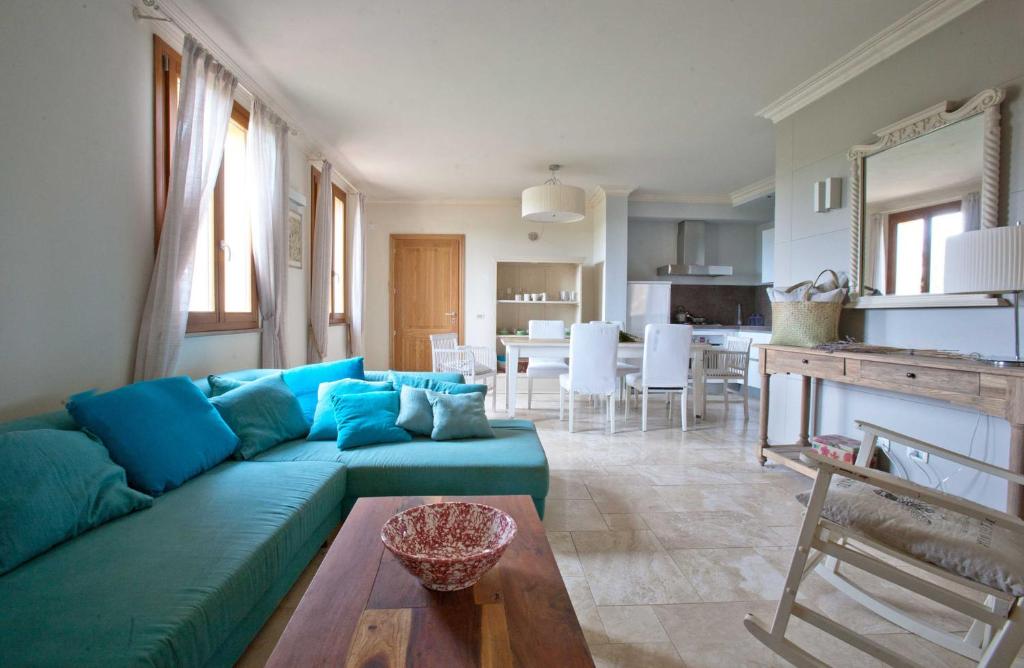 a living room with a blue couch and a kitchen at Tuscany Forever Apartments 2 in Volterra