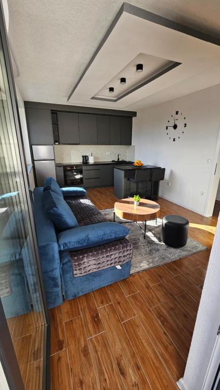 a living room with a blue couch and a table at Stan na dan Jović in Modriča