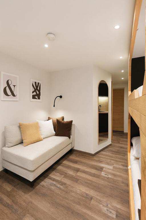 a living room with a white couch and a mirror at TinyAlps in Saalbach-Hinterglemm