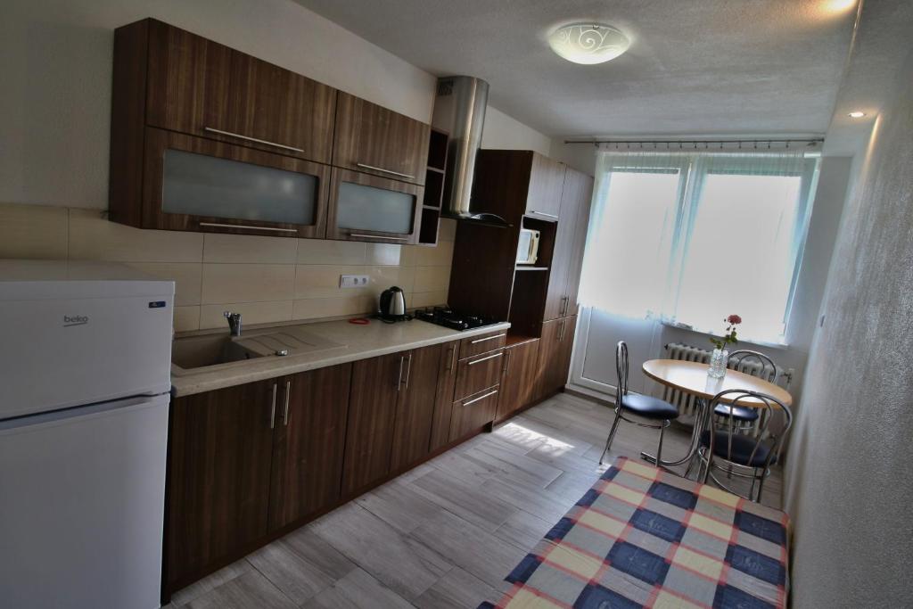 cocina con armarios de madera, mesa y ventana en Apartment Igor, en Lúčky
