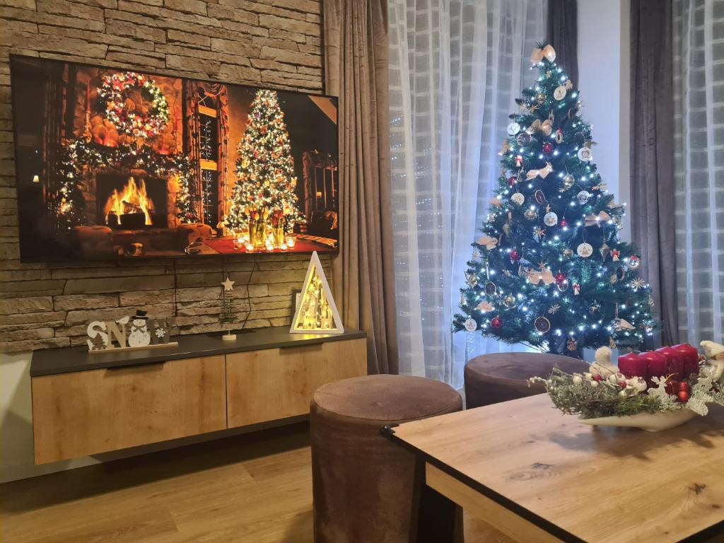 特尔乔夫Apartmán Horček, Terchová的客厅里有一棵带壁炉的圣诞树