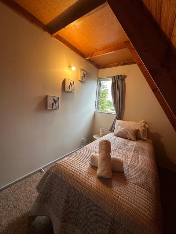 una camera da letto con un letto con due asciugamani sopra di Aurora A-Frame Twizel a Twizel