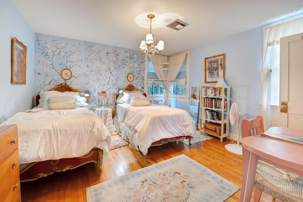 2 camas en un dormitorio con paredes azules y suelo de madera en 3BR 2BA Historic Mid City family BACH parties FQ!!, en Nueva Orleans