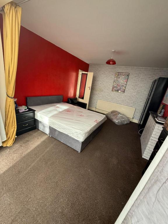 a bedroom with a bed and a red wall at spacious King bed 30FT Room in Kenton