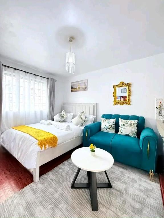 a bedroom with a bed and a couch and a table at Travel Nest in Nairobi