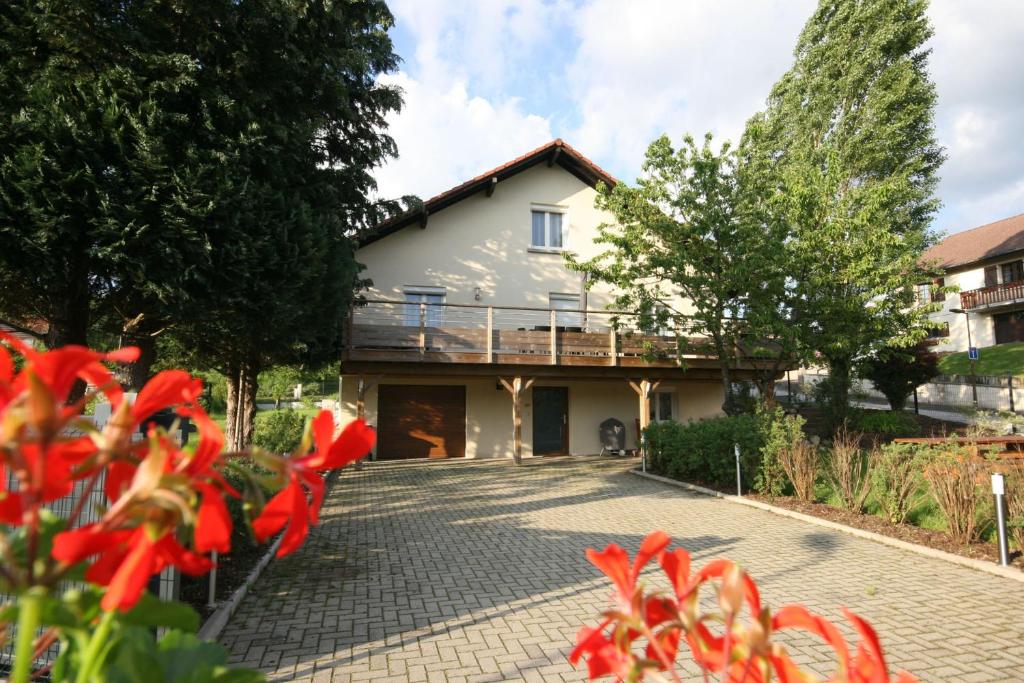 una casa con flores rojas delante de ella en Le Chalet "Les Breuches", en Ramonchamp