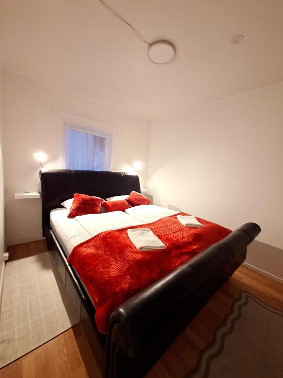 Dali 3 Ultra Central Stavanger City في ستافانغر: غرفة نوم بها سرير كبير وبطانية حمراء