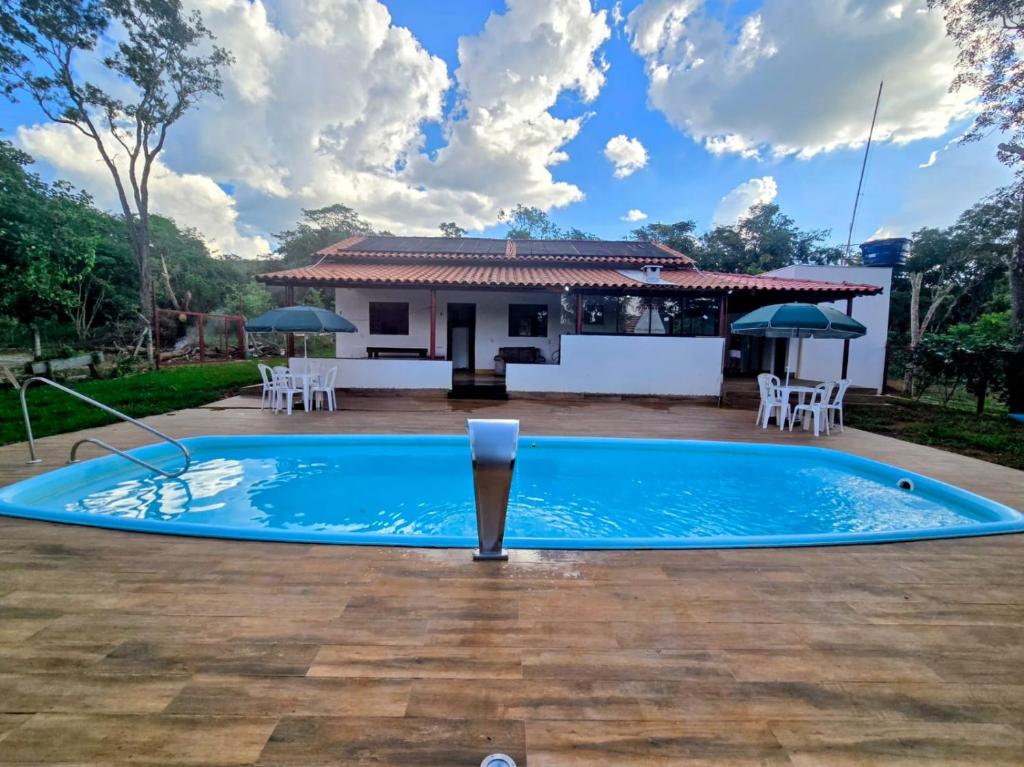 uma piscina em frente a uma casa em Chácara com piscina e lago aconchegantes em Planaltina